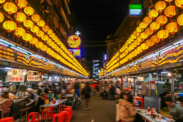 台湾観光でおすすめのグルメスポット、基隆廟口夜市。黄色い提灯が夜の屋台街を照らす幻想的な景色。