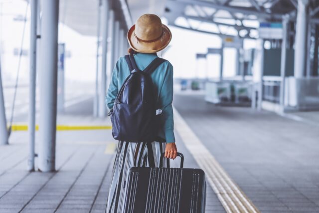 キャリーケースを引いて旅行する女性の後ろ姿