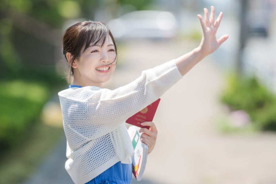 手を挙げて合図する女性